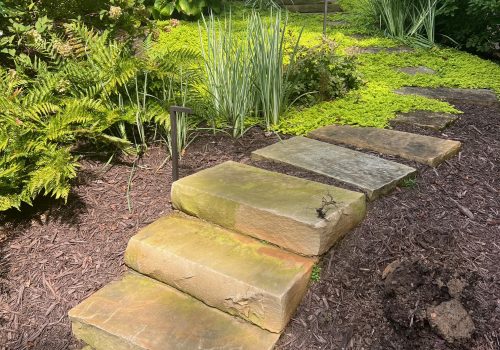 An outdoor garden and stone walkway from StoneAge Stonescapes, a Landscape Contractor in Milton GA